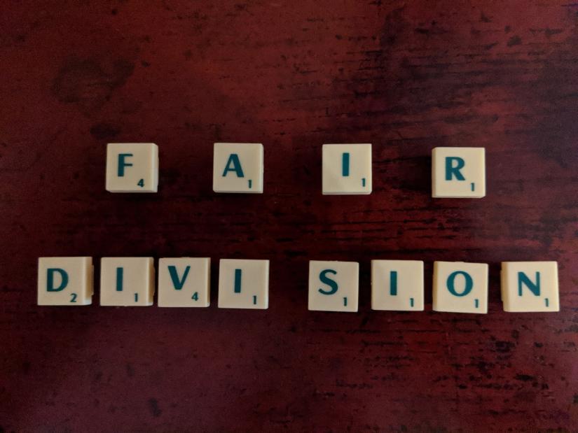 The words 'Fair Division' with Scrabble tiles, with the word division divided in half