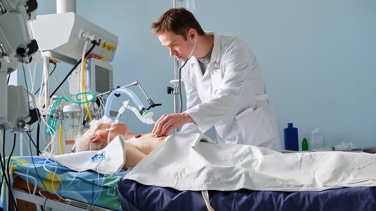 Doctor checking a patient who is using a ventilator