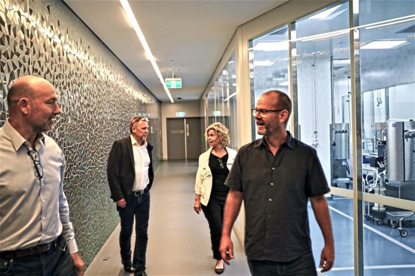 Four people walking up a corridor