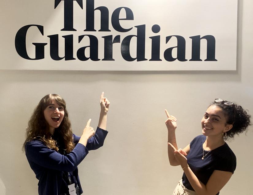 Rafqa Tourma smiling and pointing at the Guardian signage