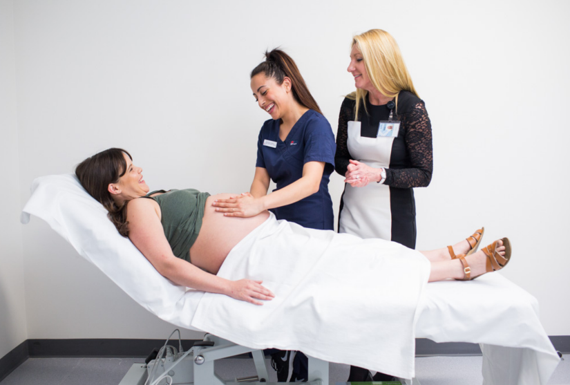 Dr Allison Cummins observing a student interact with a pregnant woman
