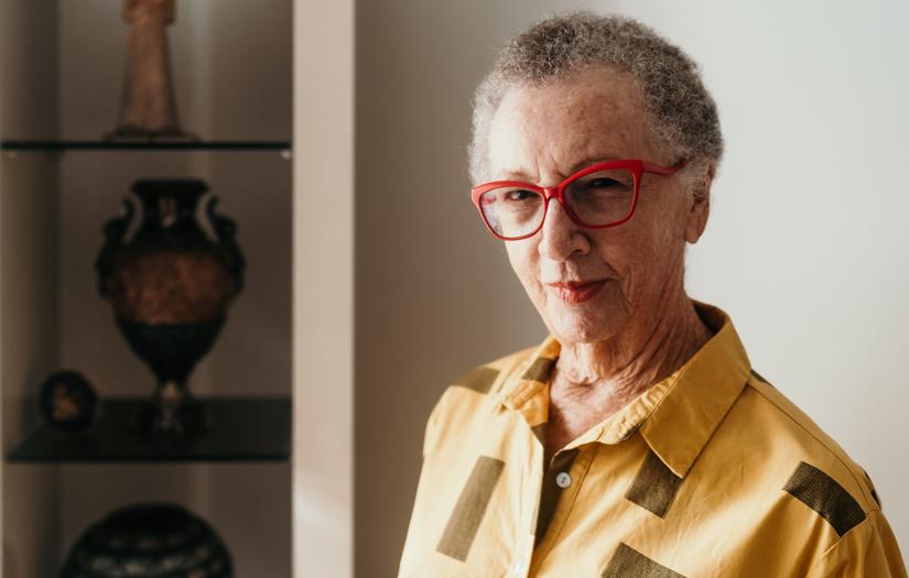 Laurie Cowled in a yellow shirt and red glasses looking at the camera