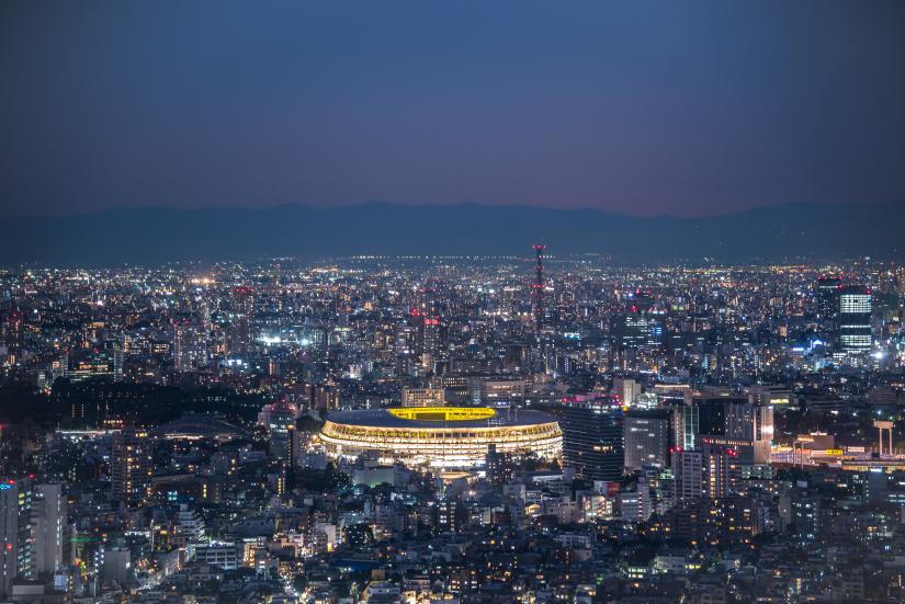 Overhead aerial view of the new National Stadium with Tokyo's skyline in twilight time, fully completed main stadium for Tokyo Olympic Summer Games 2020