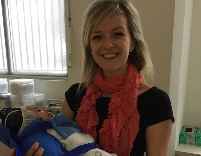 Researcher Monique Jones holds baby ready for MRI