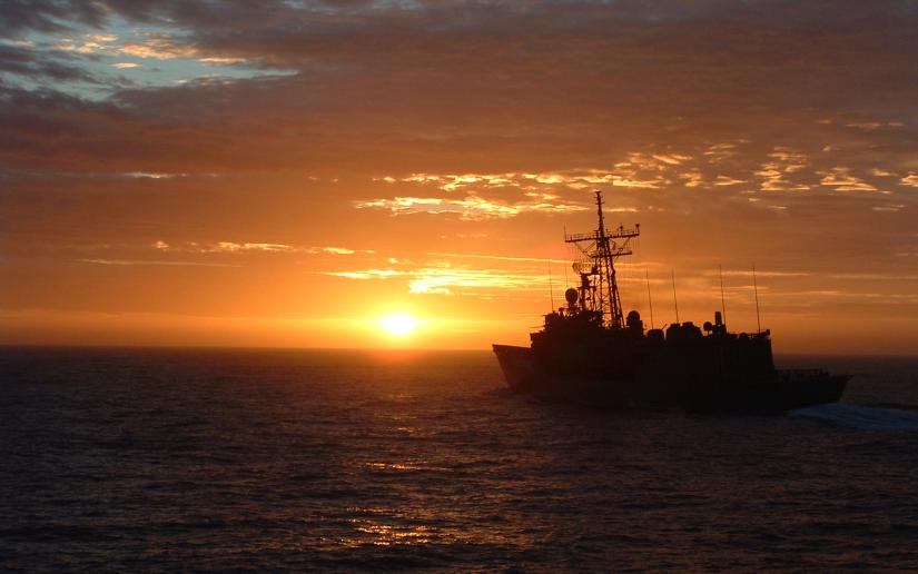 A naval ship at sunset.