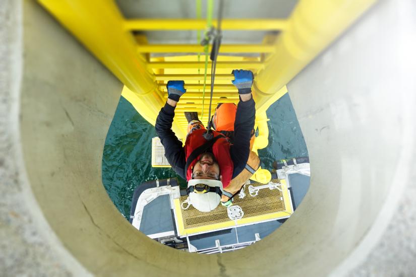 Energy workers climbing up an offshore wind turbine