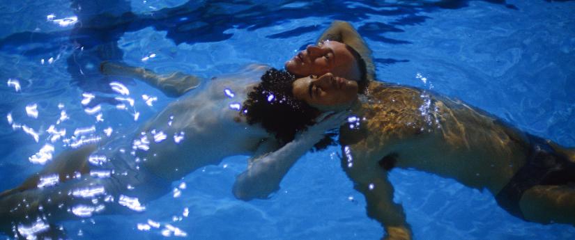 Two men floating in the swimming pool