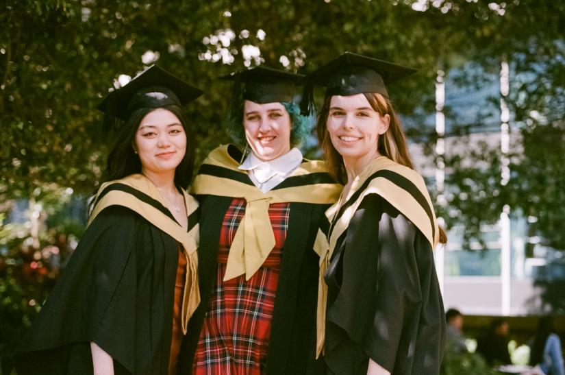 Katrina, Holly and Julia stand arm-in-arm in their Graduation attire
