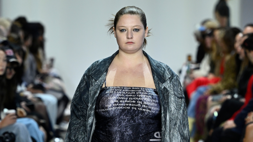 Fashion model on the runway wearing an Alix Higgins dress and jacket with hair pulled back