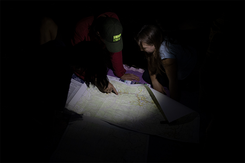 People huddled around a map in the dark