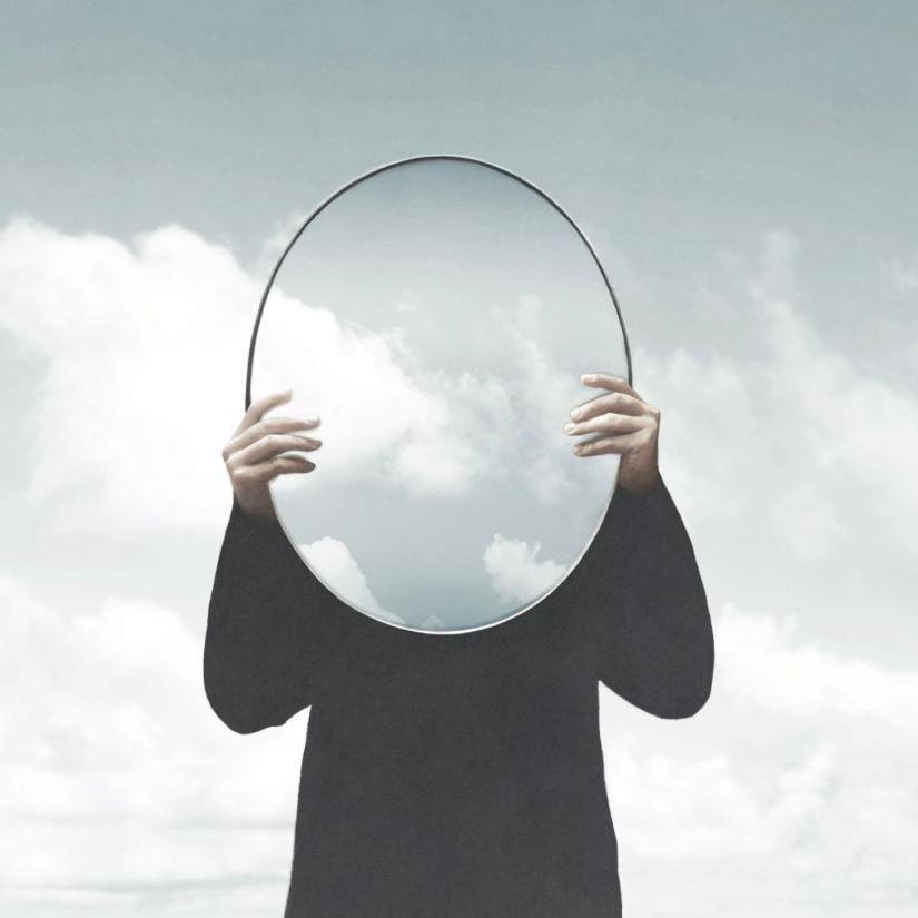 A man holds up a mirror
