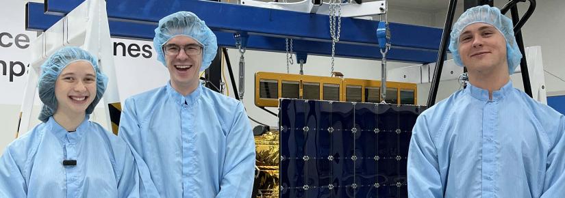 Three UTS students in protective gear stand with a satellite at UTS Tech Lab.
