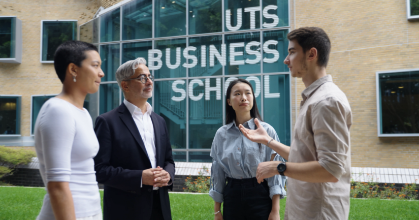 Three students and an academic standing in front of the UTS Business School 