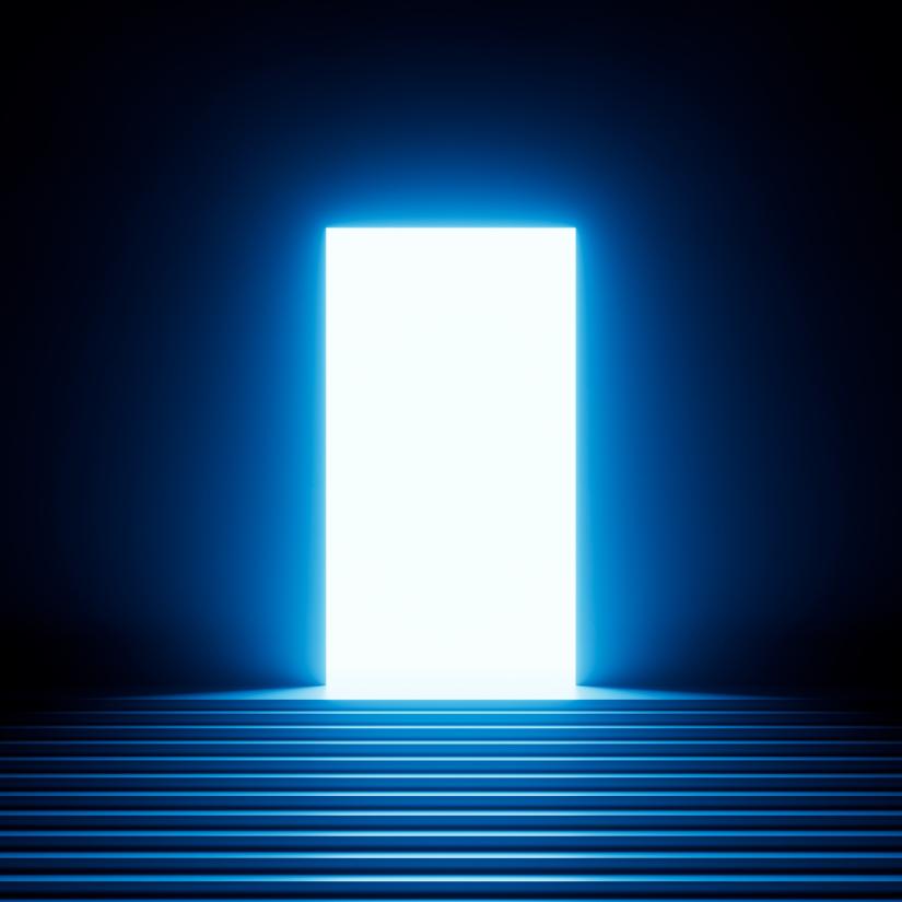 A dark hallway illuminated by light emanating from an open door
