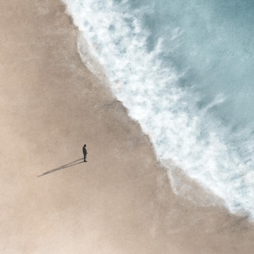 A single lone figure stands at the shore as waves crash in