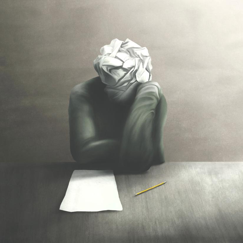 A face made of crumpled paper looks down on a blank page and pencil