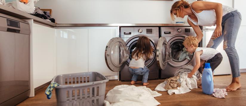 Photo of family loading a washing machine with dishwasher nearby
