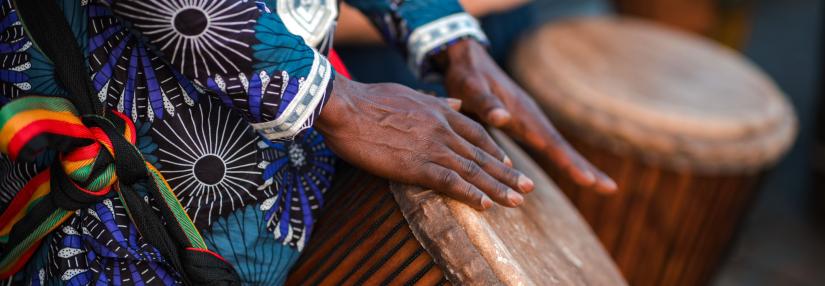 Women playing tradtional african drum in traditional garmet
