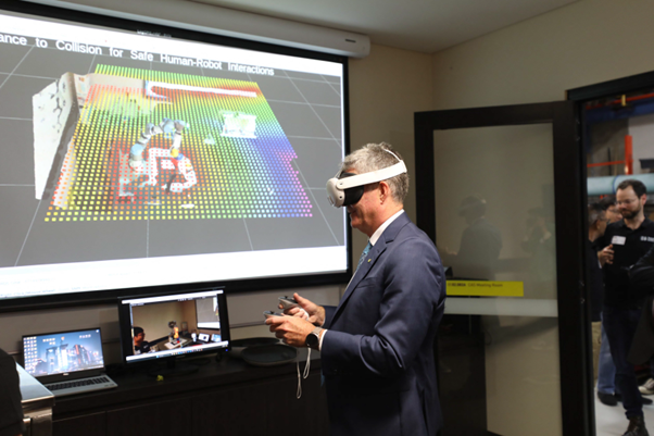 Hon. Steve Whan wears a mixed-reality headset and uses hand-held controllers.