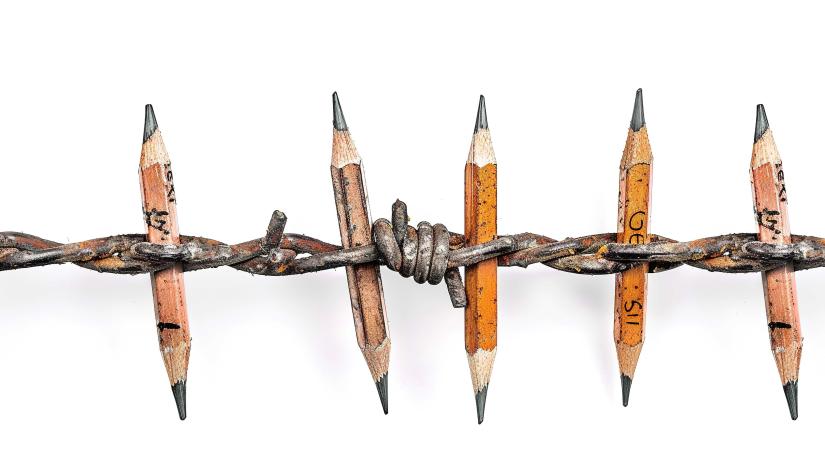 sharpened pencils are embedded and held in a wired piece of fence