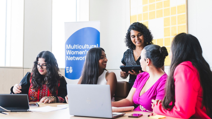 Five multicultural women in a workplace setting