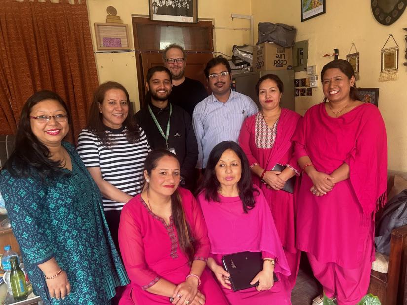 A group of academics from UTS and Nepal smile in a home