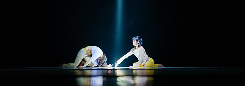 2 dancers on the stage, black background