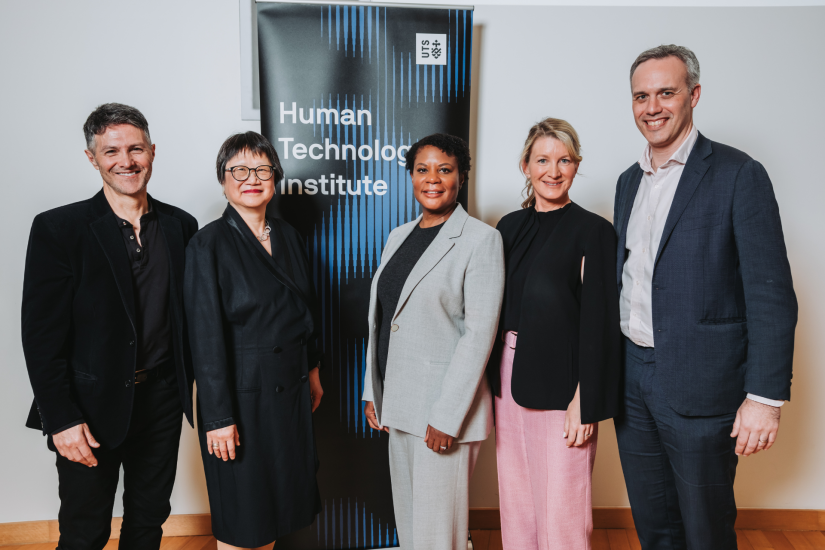 Image of five people standing in front of banner