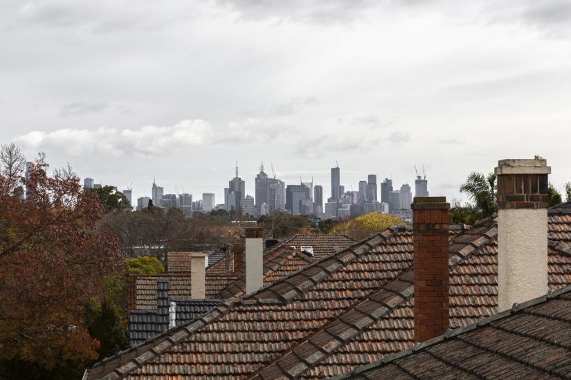 Skyline of Melbourne above some residential buildings.