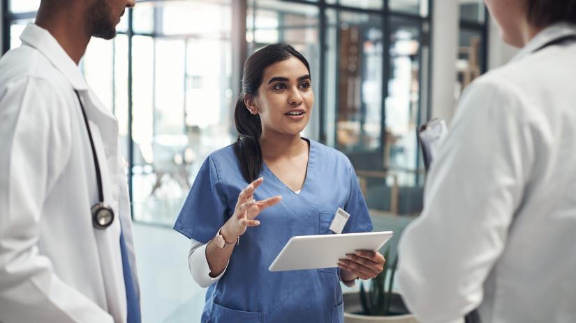 Health staff chat in a hospital corridor