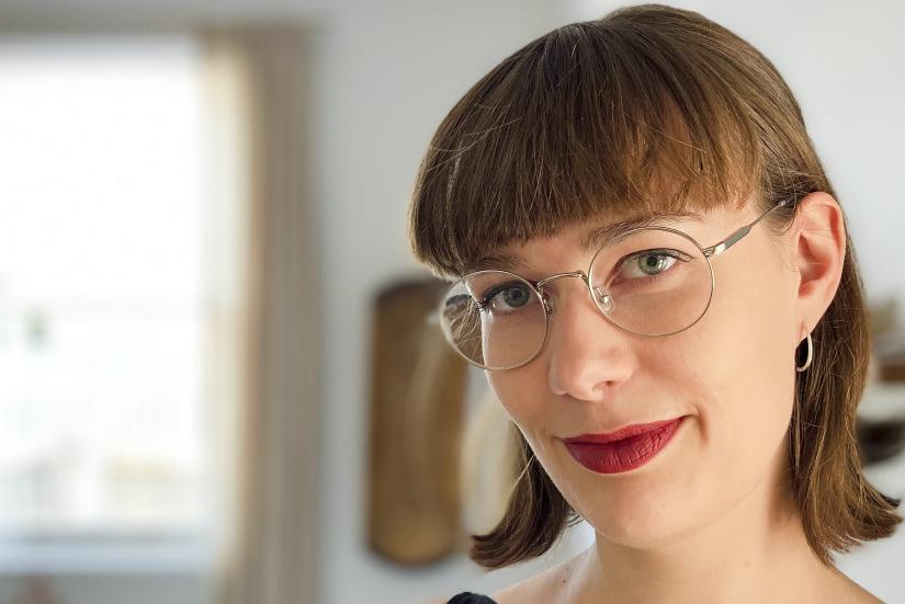 headshot image of female with cropped brown hair, glasses and red lipstick