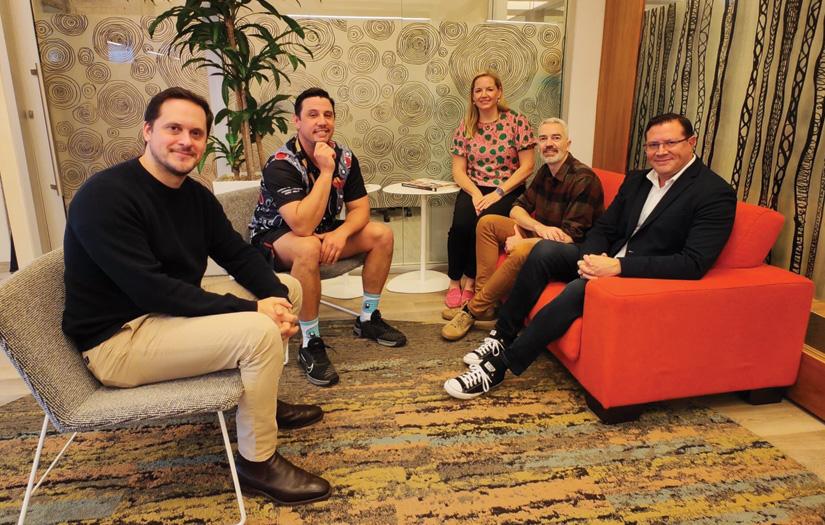 Group shot of Jumbunna staff and ACER representatives siting in a circle in lounge chairs smiling and looking at the camera