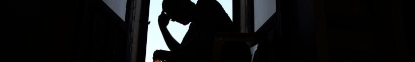 silhouette of a man with hand on forehead