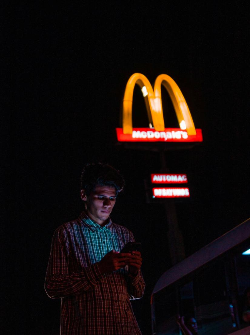 McDonalds sign and man with smartphone