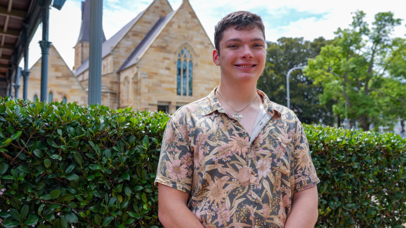 Student smiling in front of a church building. 