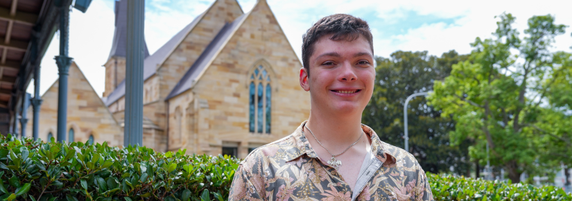 Student smiling for a photo in front of a church building.