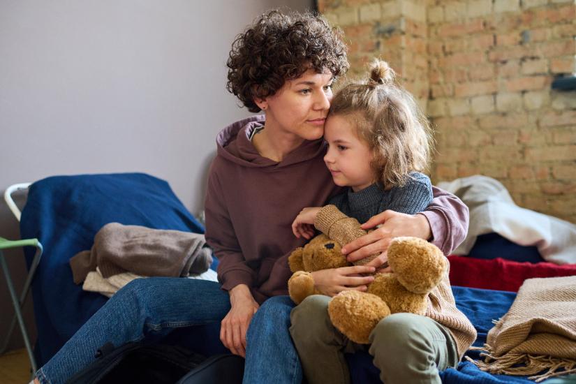 Woman gives child a hug. Adobe Stock By pressmaster.