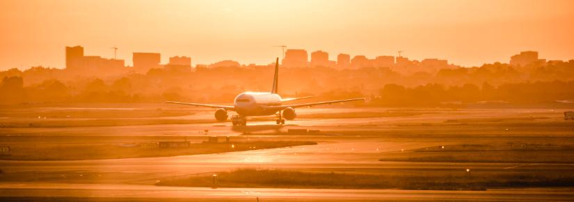 plane on runway at sunset. Adobe Stock