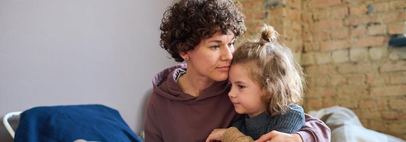 Woman hugs a child. Adobe Stock image.