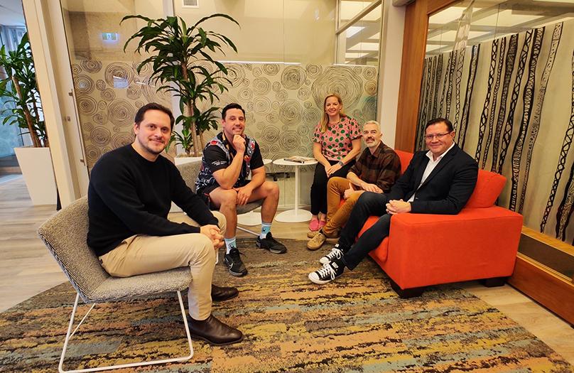 Group shot of Jumbunna staff and ACER representatives siting in a circle in lounge chairs smiling and looking at the camera