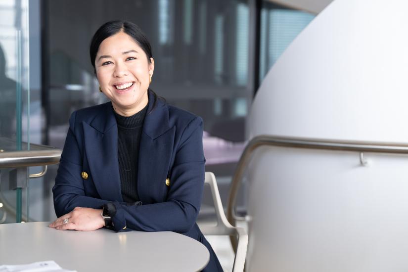 Woman sitting at desk with arms folded, smiling