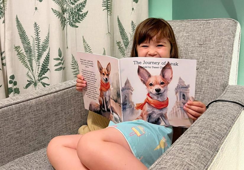 Child sitting on lounge, reading a book