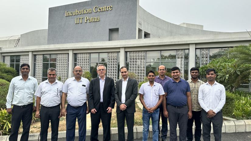 Group of men standing in front of a concret building with a sign that says "Incubation Centre IIT Patna."