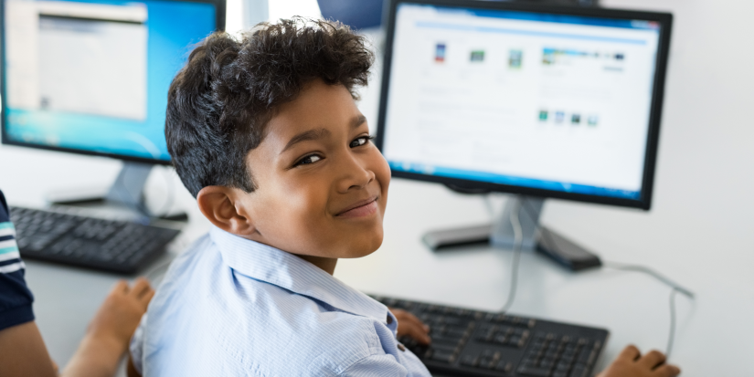 Young school boy in front of a computer.