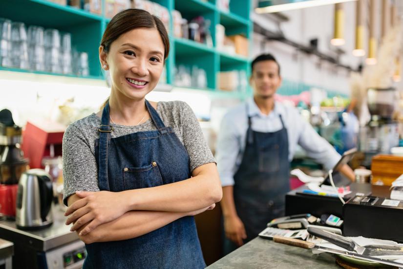 Female worker behind register in a local small business.