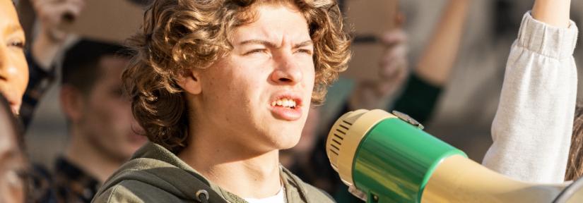 Young person with a megaphone. Adobe Stock image by Lomb.