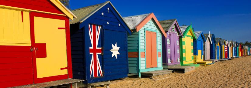 A row of colourful painted shacks on a beach