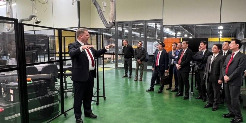 Man presents to group standing in lab.