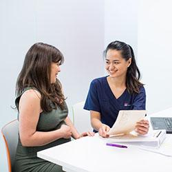 A midwifery student smiling with a pregnant patient
