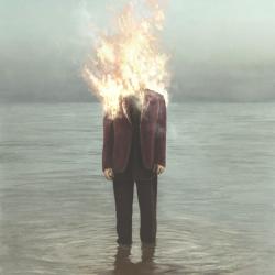 A man in water, his head aflame